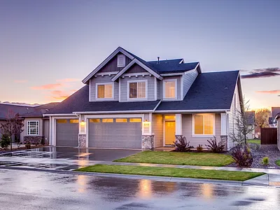 Suburban home with dark asphalt driveway at dusk