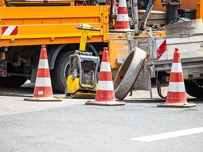 Paving truck, compactor, and traffic cones on commercial job
